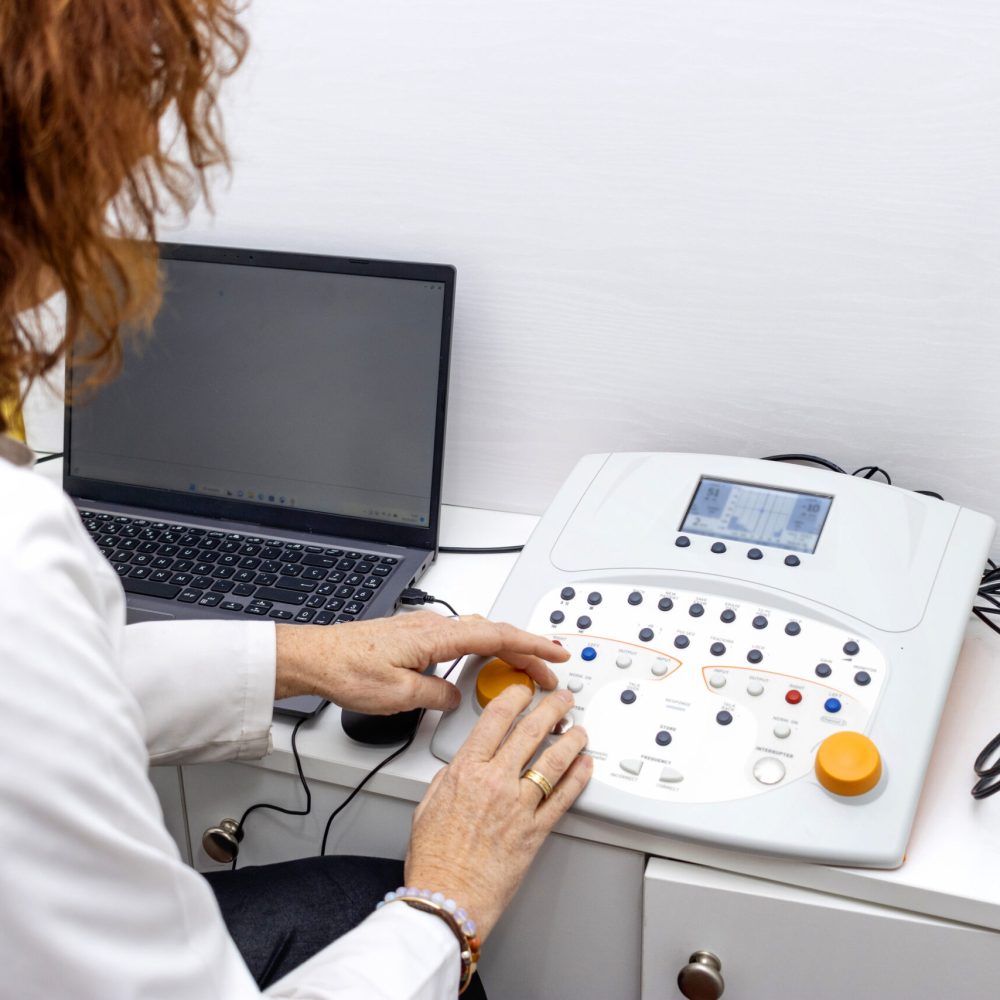 Joyous middle-aged doctor performing an audiometry test